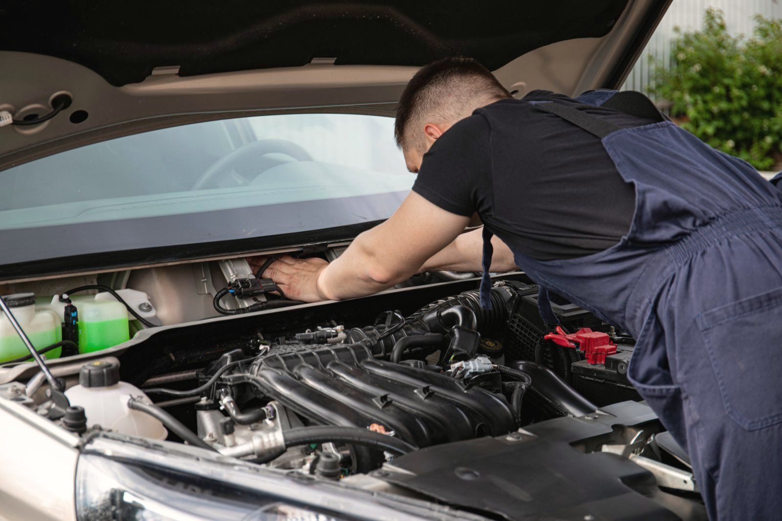 Mechanic leaning into an open engine bay