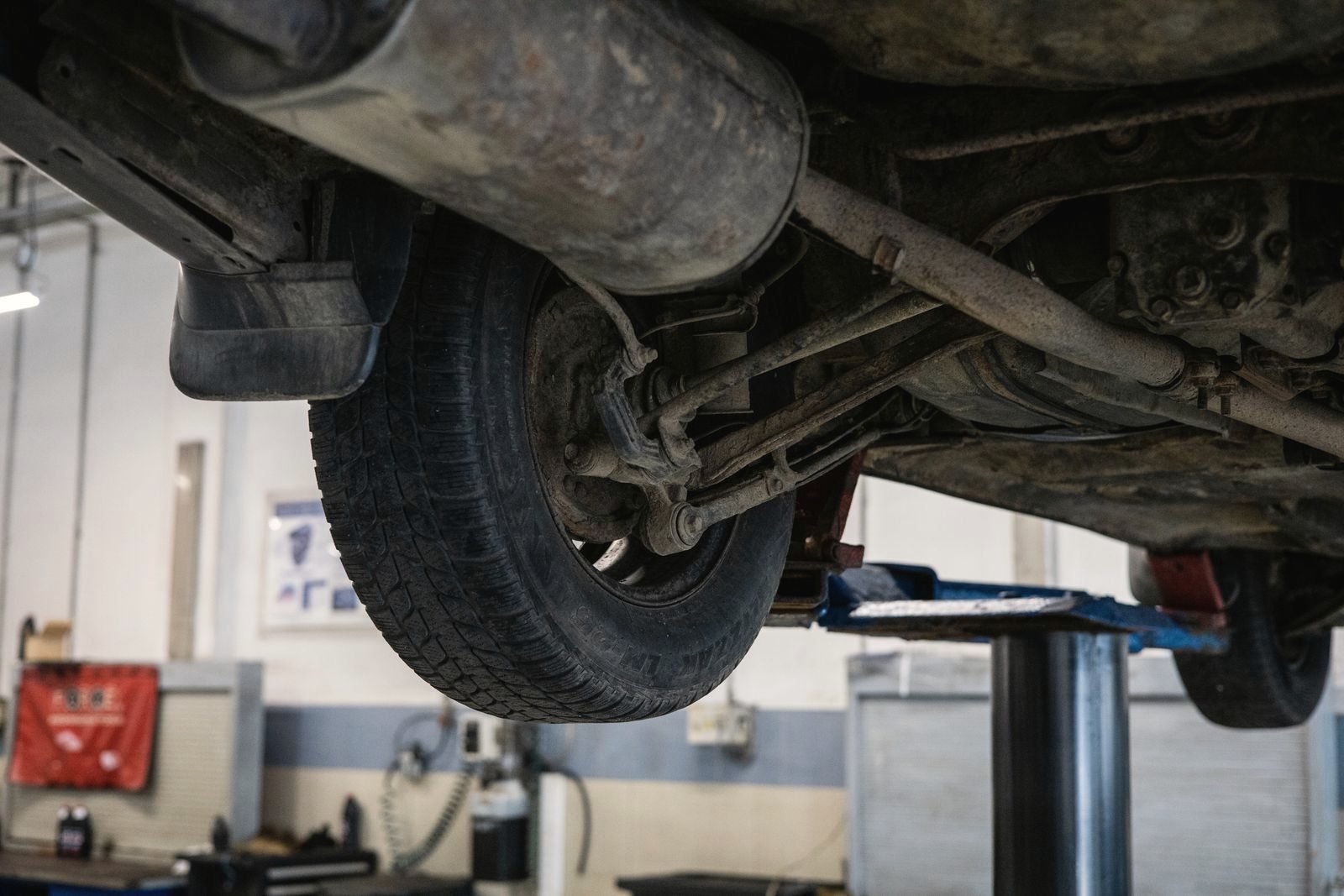 Underside of a car on a lift, suspension and exhaust in view